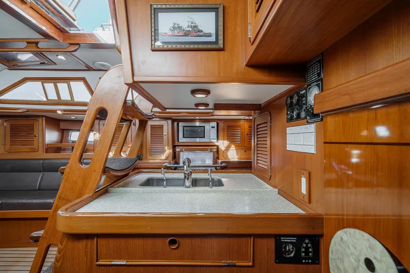 Slide: The Image of Luxurious 2012 Hylas 46 yacht interior with wooden cabinetry and modern kitchen amenities. - 36