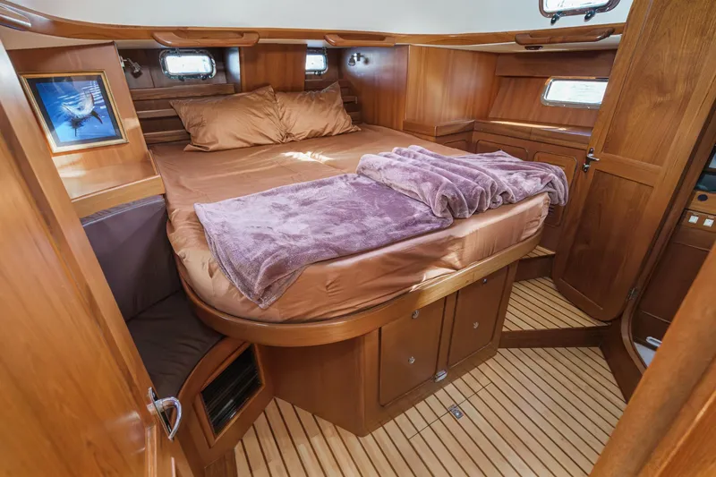 Slide: The Image of Luxurious cabin interior of 2012 Hylas 46 yacht with wooden finish and cozy bedding. - 4