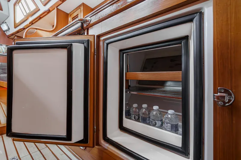 Slide: The Image of Open fridge on 2012 Hylas 46 yacht interior with water bottles inside. - 41