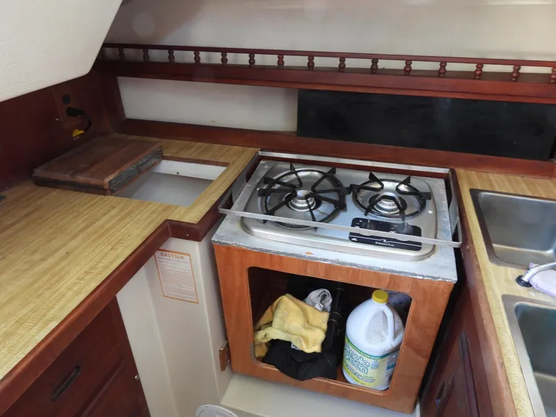 Slide: The Image of 1983 Catalina 30 kitchen area with stove and sink. - 11