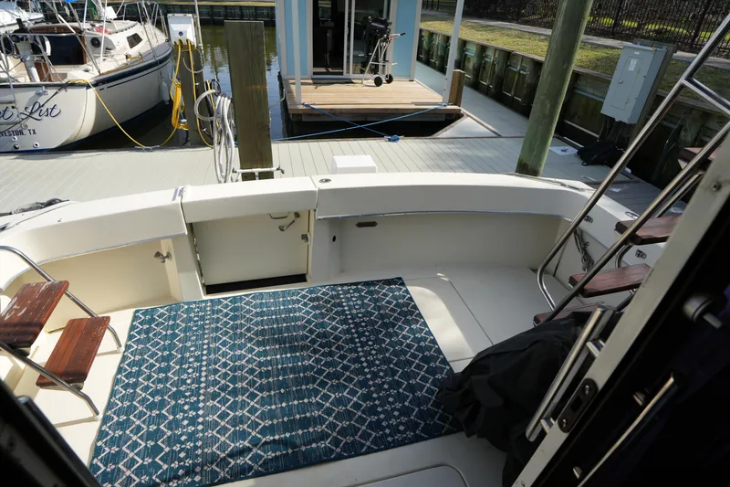 Slide: The Image of 1987 Hatteras 36 Convertible boat deck with patterned rug at marina. - 19