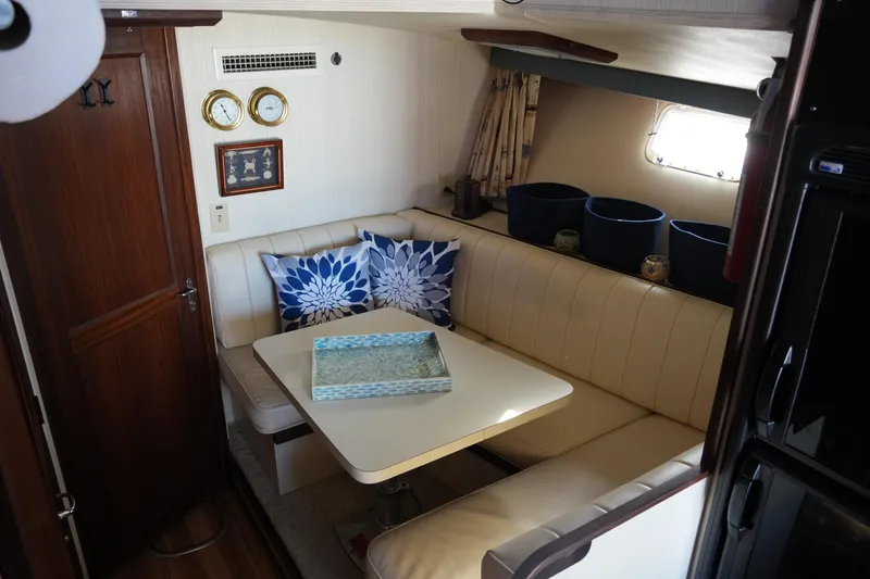 Slide: The Image of Interior of 1987 Hatteras 36 Convertible yacht with cozy dining area and nautical decor. - 27