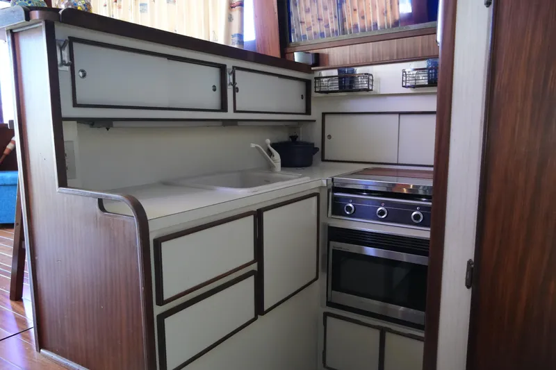 Slide: The Image of Compact kitchen in 1987 Hatteras 36 Convertible yacht with stove, sink, and storage cabinets. - 30