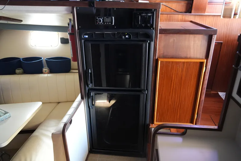 Slide: The Image of 1987 Hatteras 36 Convertible yacht interior with fridge and seating area. - 32
