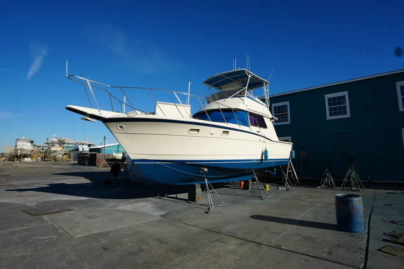 Slide: The Image of 1987 Hatteras 36 boat on dry dock, blue sky background, marina setting. - 39