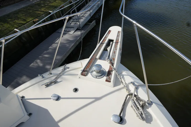 Slide: The Image of Bow of 1987 Hatteras 36 Convertible yacht with anchor chain and dock view. - 4