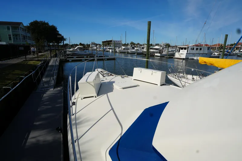 Slide: The Image of 1987 Hatteras 36 Convertible yacht docked at a marina under clear blue skies. - 6