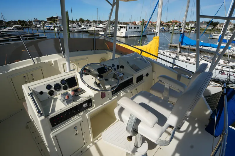 Slide: The Image of 1987 Hatteras 36 Convertible yacht helm with dual seats, docked in a marina. - 9