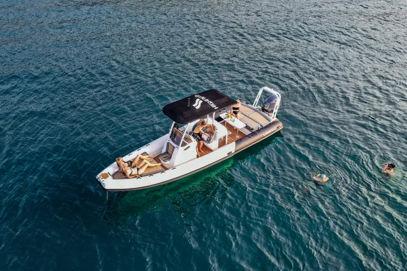 Slide: The Image of 2025 Highfield Sport 900 boat on open water with swimmers nearby. - 2