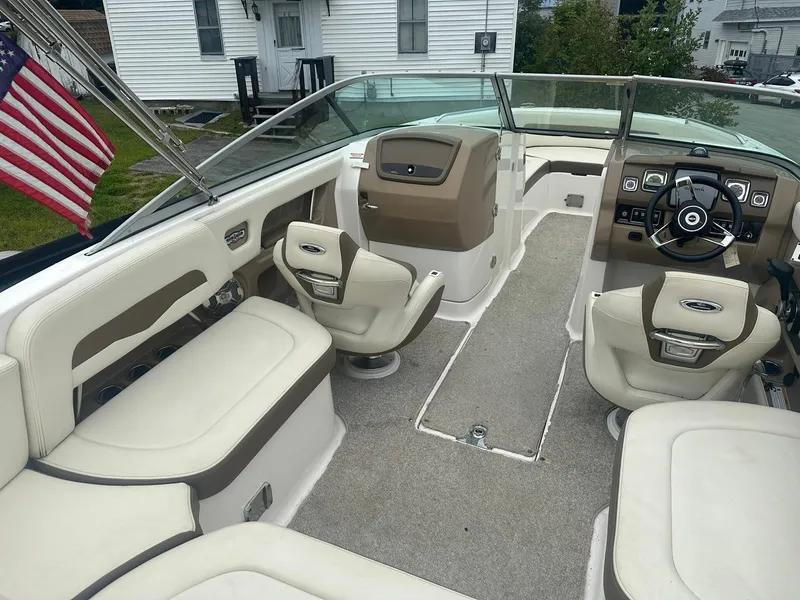 Slide: The Image of 2013 Chaparral 246 SSi boat interior with beige seating and American flag. - 10