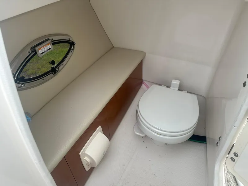 Slide: The Image of 2013 Chaparral 246 SSi boat interior with toilet and seating area. - 8