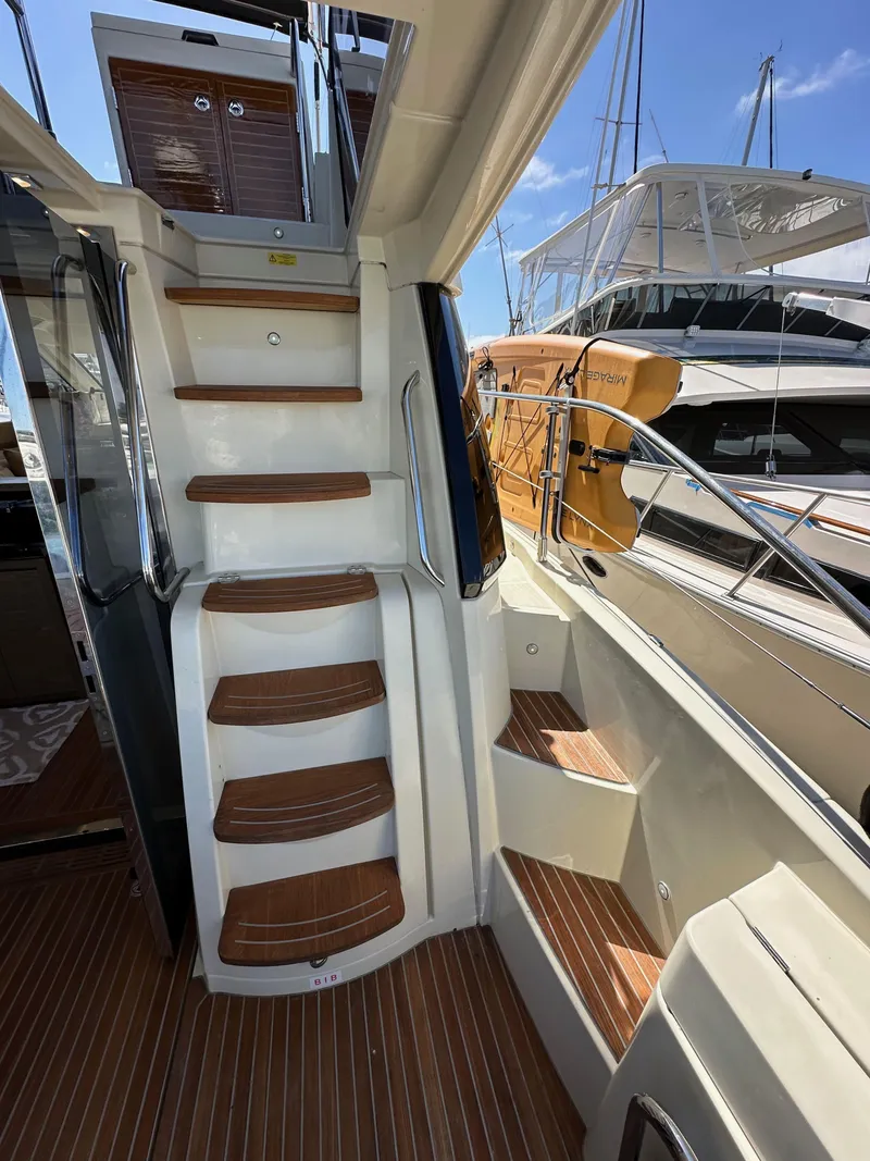 Slide: The Image of Staircase on 2017 Beneteau Monte Carlo 5 MC5 yacht, showcasing teak steps and sleek design. - 14