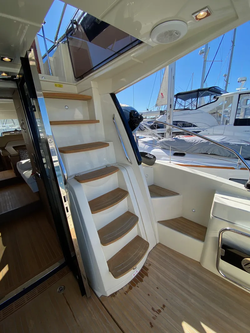 Slide: The Image of Interior view of 2017 Beneteau Monte Carlo 5 MC5 yacht with wooden stairs and marina backdrop. - 35