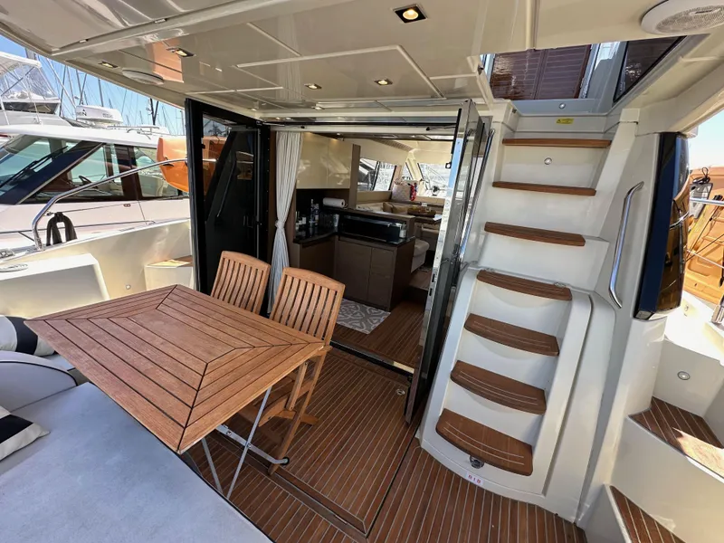 Slide: The Image of 2017 Beneteau Monte Carlo 5 MC5 yacht interior with wooden table and stairs. - 37