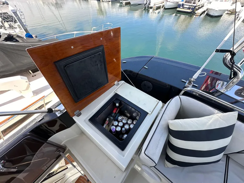 Slide: The Image of Beneteau Monte Carlo 5 MC5 yacht with open cooler and striped cushion, docked at marina. - 41