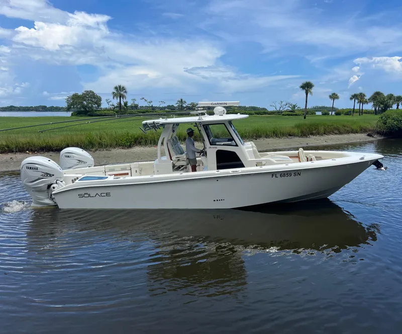 Slide: The Image of 2020 Solace 345 CC boat cruising on a calm river under a clear blue sky. - 1