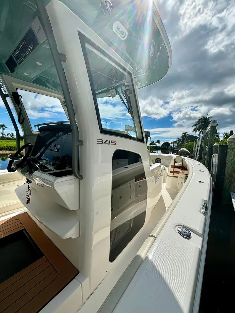 Slide: The Image of 2020 Solace 345 CC boat, sleek design, sunny day, palm trees in background. - 11