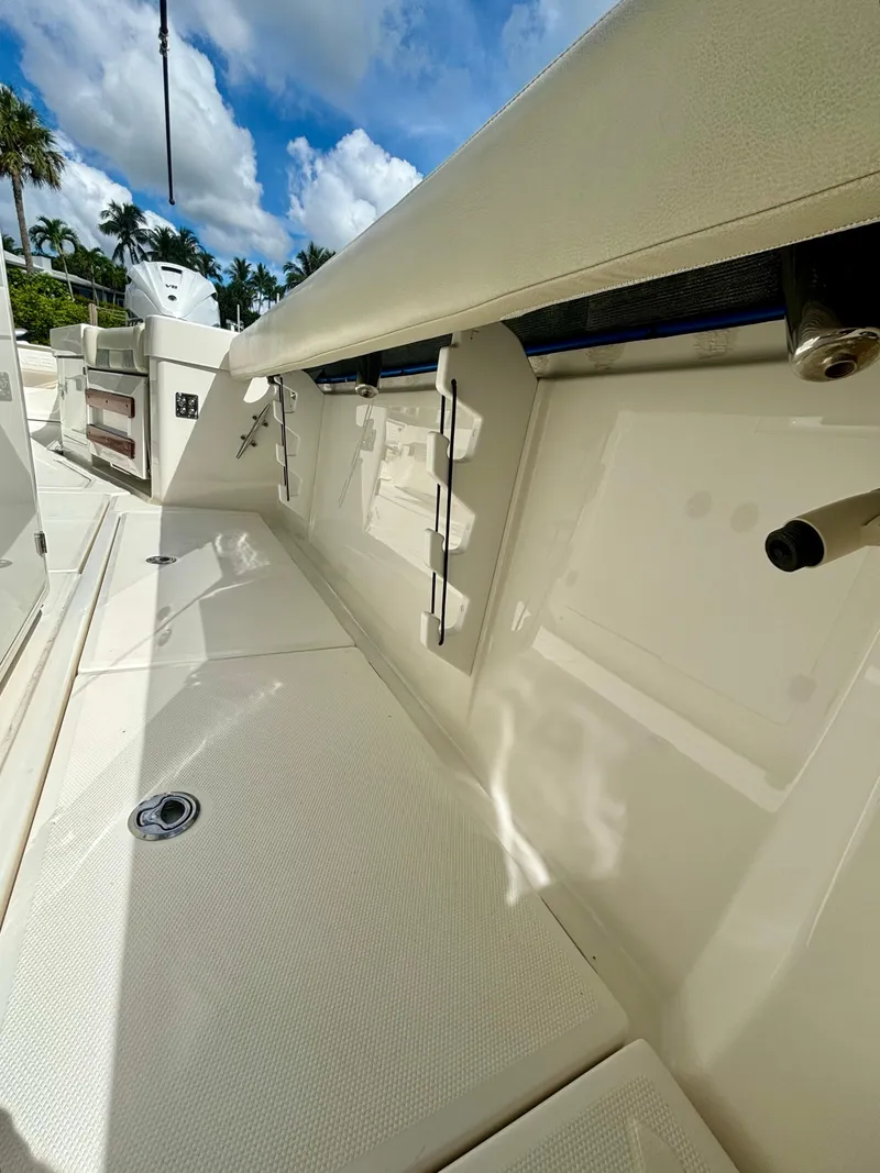 Slide: The Image of 2020 Solace 345 CC boat deck with storage compartments, under a clear blue sky. - 16