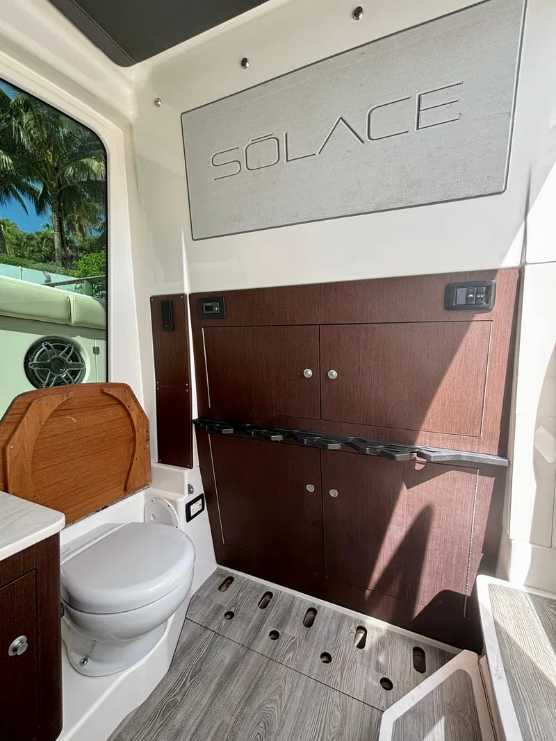 Slide: The Image of 2020 Solace 345 CC boat interior with modern wood cabinetry and toilet. - 23
