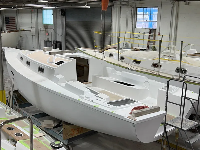 Slide: The Image of 2025 Tartan 335 sailboat under construction in a workshop. - 4