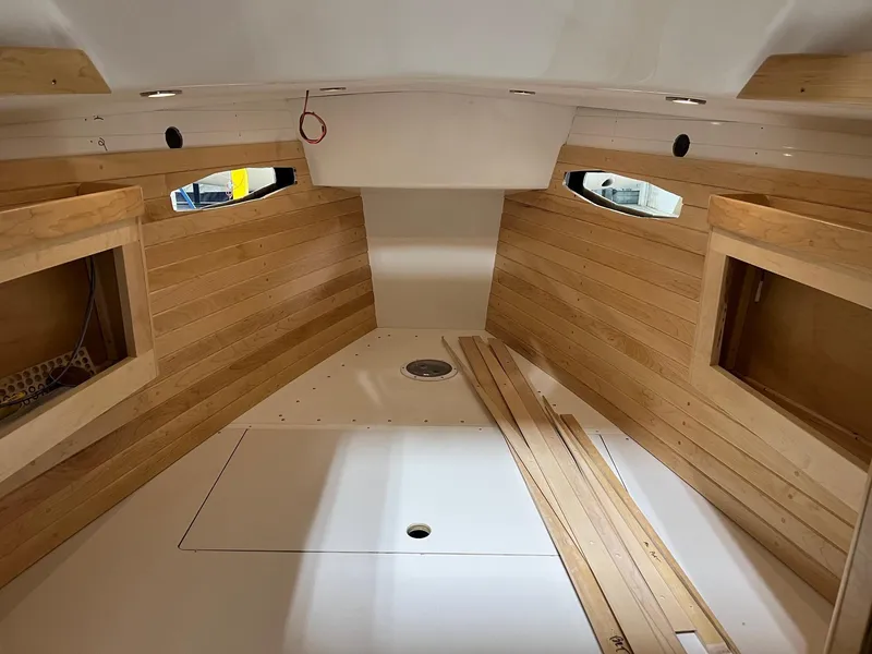 Slide: The Image of Interior of 2025 Tartan 335 sailboat with wooden paneling and portholes. - 6