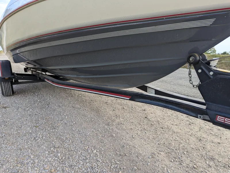 Slide: The Image of 1990 Bayliner 180 Capri boat on trailer, side view, gravel background. - 10