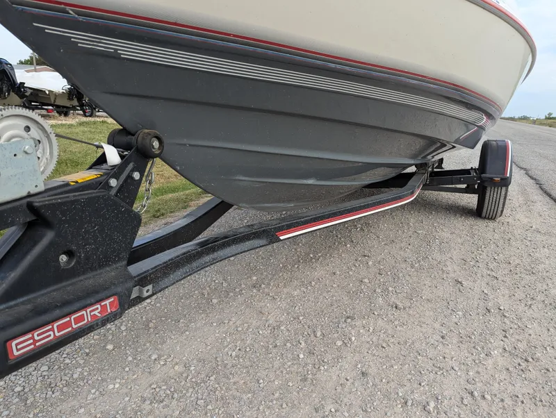 Slide: The Image of 1990 Bayliner 180 Capri boat on Escort trailer, parked on gravel road. - 11