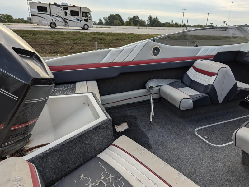 Slide: The Image of 1990 Bayliner 180 Capri interior with worn seats, parked near highway. - 14