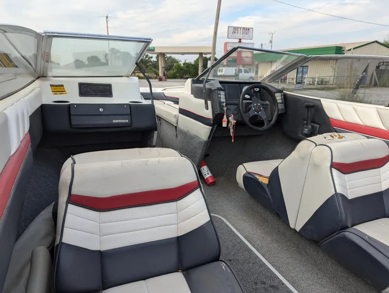 Slide: The Image of Interior of 1990 Bayliner 180 Capri boat with red, white, and black seating. - 17