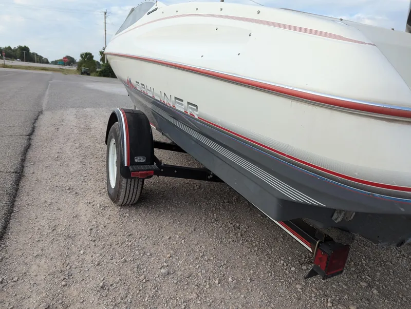 Slide: The Image of 1990 Bayliner 180 Capri boat on trailer, parked on gravel road. - 4