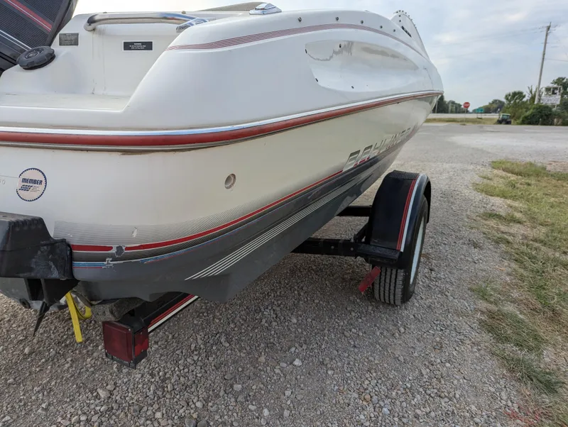 Slide: The Image of 1990 Bayliner 180 Capri boat on trailer, parked on gravel road. - 6