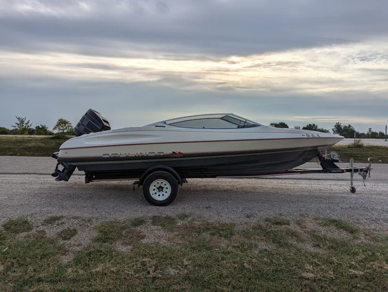 Slide: The Image of 1990 Bayliner 180 Capri boat on trailer under cloudy sky. - 8