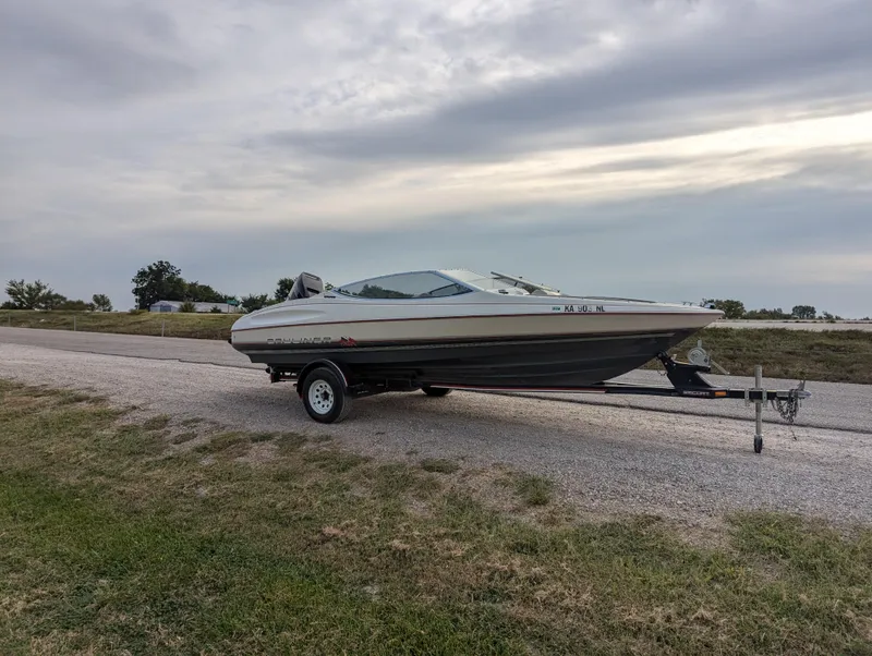 Slide: The Image of 1990 Bayliner 180 Capri boat on trailer, parked on a rural road. - 9