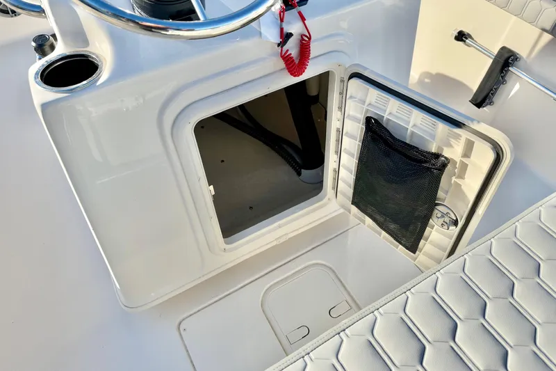 Slide: The Image of 2025 Carolina Skiff 21 LS boat interior with open storage compartment and cushioned seat. - 15