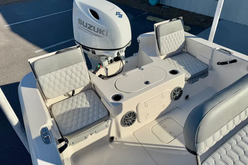 Slide: The Image of 2025 Carolina Skiff 21 LS boat at dealership, featuring elevated seating and Suzuki engine. - 17