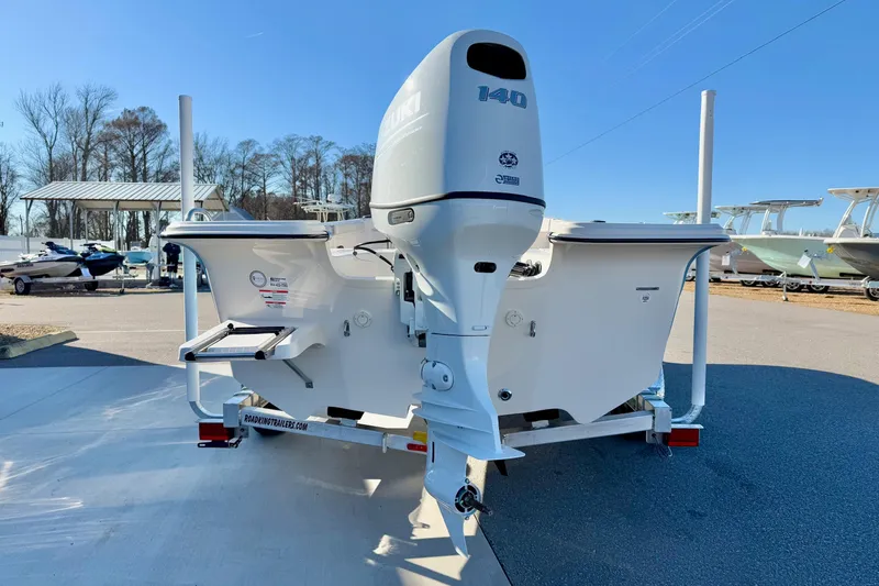 Slide: The Image of 2025 Carolina Skiff 21 LS boat with Suzuki 140 outboard motor, parked outdoors. - 2