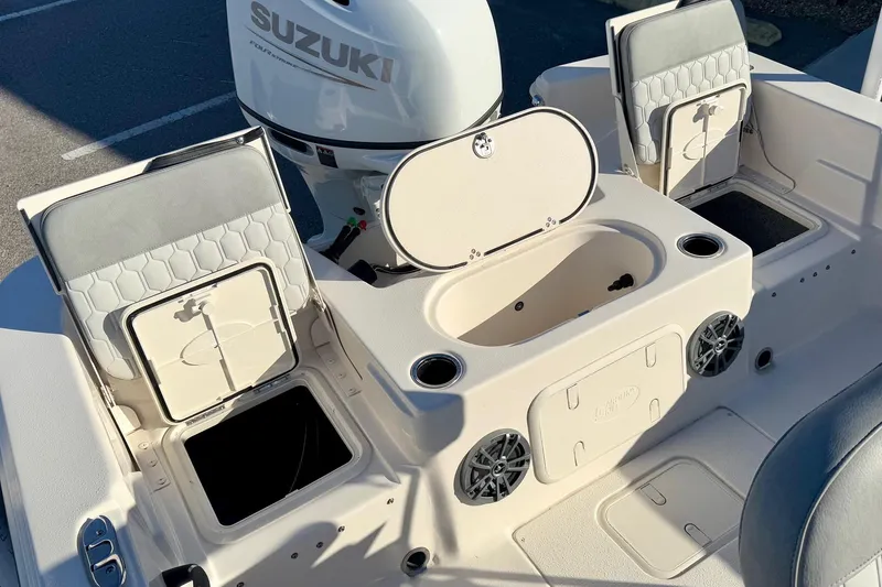 Slide: The Image of 2025 Carolina Skiff 21 LS boat interior with Suzuki engine, storage compartments, and seating. - 31