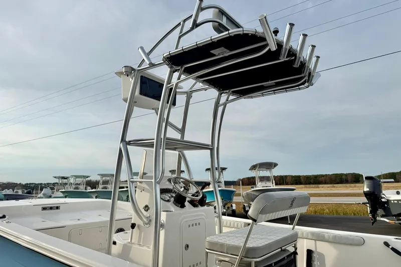Slide: The Image of 2025 Carolina Skiff 21 LS boat with T-top and console, docked outdoors. - 32