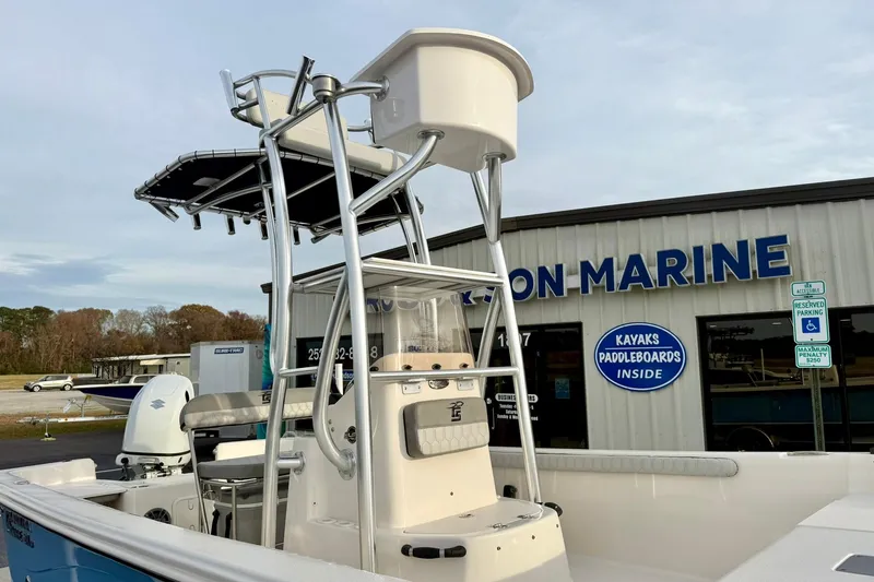 Slide: The Image of 2025 Carolina Skiff 21 LS boat with tower, parked outside a marine store. - 34