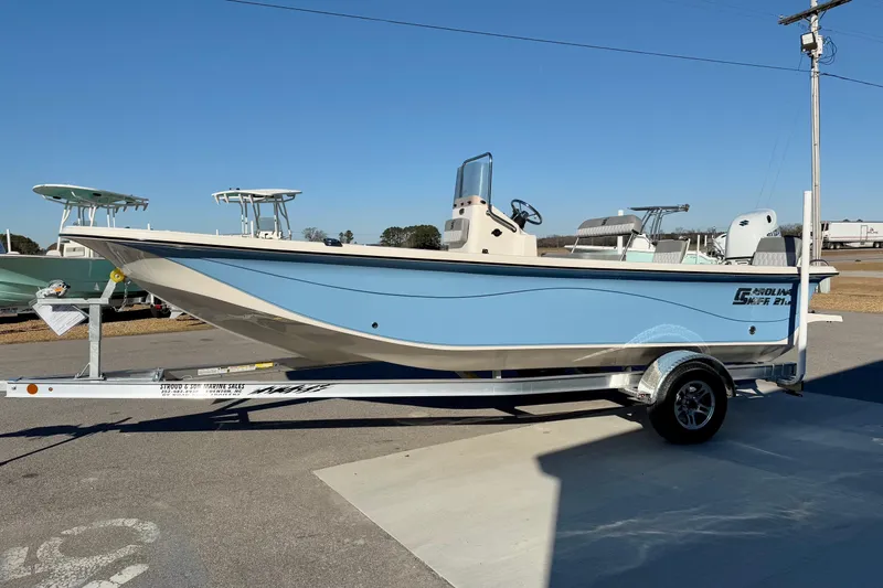 Slide: The Image of 2025 Carolina Skiff 21 LS boat on trailer, featuring a blue hull and Suzuki outboard motor. - 5