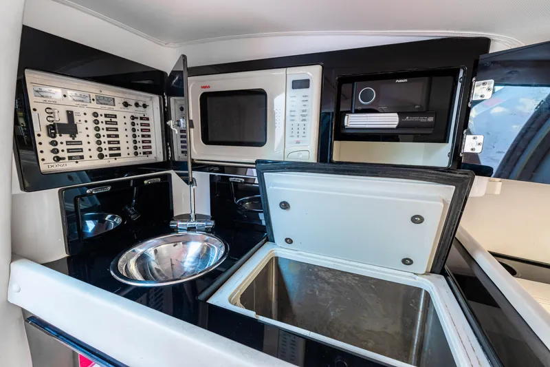 Slide: The Image of 2003 Donzi 33 ZX Daytona boat interior kitchen with sink, microwave, and control panel. - 16