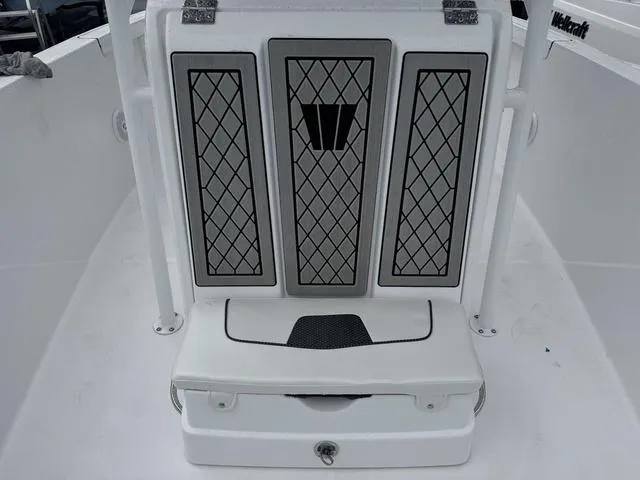 Slide: The Image of 2025 Wellcraft 202 Fisherman boat interior with cushioned seating and storage compartment. - 16