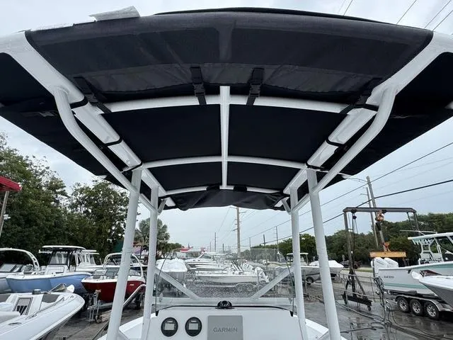 Slide: The Image of 2025 Wellcraft 202 Fisherman boat with T-top canopy, parked in a marina. - 4