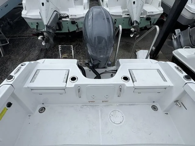 Slide: The Image of 2025 Wellcraft 202 Fisherman boat, rear view with motor and storage compartments. - 8