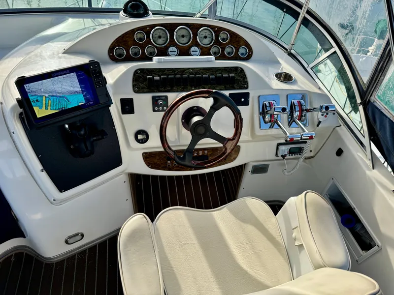 Slide: The Image of 2002 Bayliner 3488 Command Bridge helm with navigation controls and steering wheel. - 11