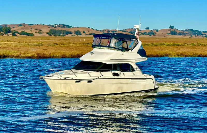 Slide: The Image of 2002 Bayliner 3488 Command Bridge cruising on a scenic river. - 2