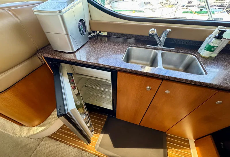 Slide: The Image of 2002 Bayliner 3488 Command Bridge kitchen with sink, mini fridge, and countertop. - 27