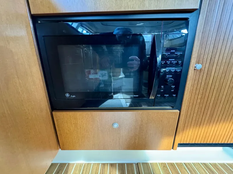 Slide: The Image of Microwave in 2002 Bayliner 3488 Command Bridge yacht kitchen, wood paneling. - 28