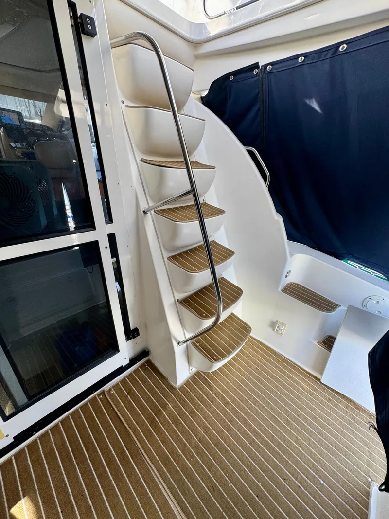 Slide: The Image of Interior stairs of 2002 Bayliner 3488 Command Bridge with wood accents and blue curtain. - 29