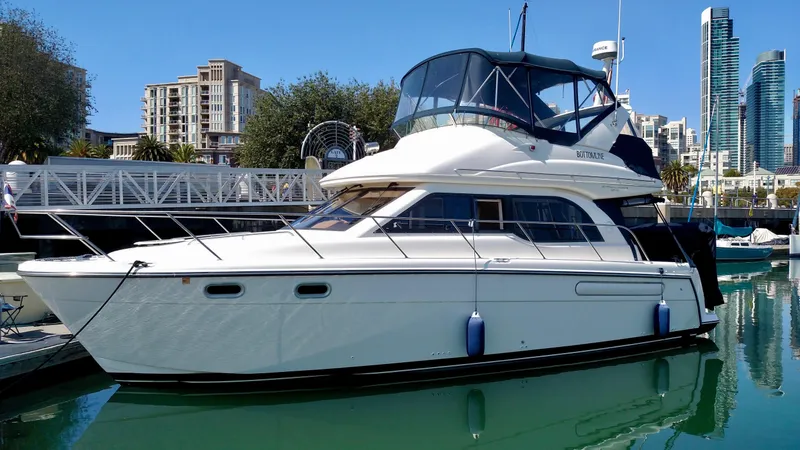 Slide: The Image of 2002 Bayliner 3488 Command Bridge yacht docked in a marina with city skyline. - 5